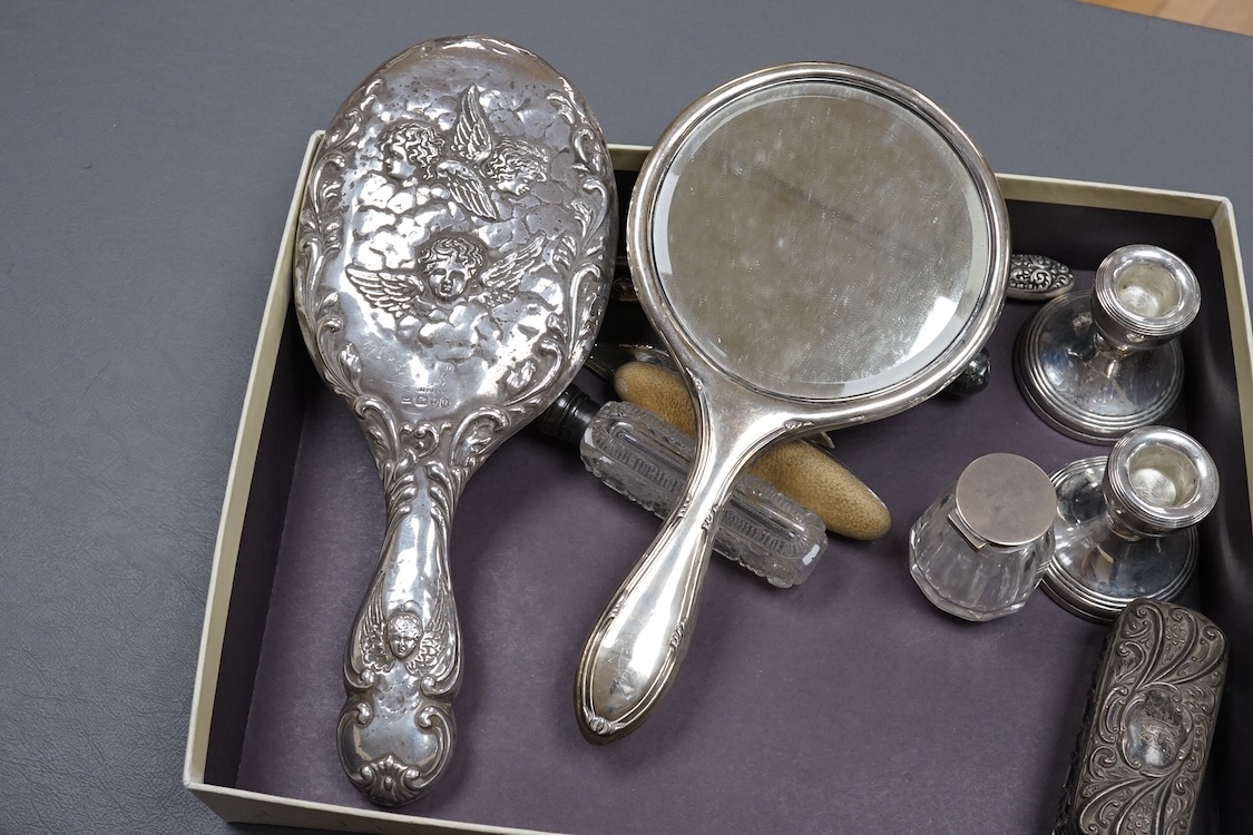 Two silver mounted hand mirrors including Reynold's Angels, Chester, 1899, 26.7cm, together with four silver mounted dressing table implements, a pair of silver mounted dwarf candlesticks and four assorted silver mounted